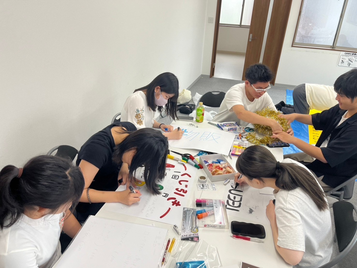 高校生スタッフが物販ブースのポップ作成している様子